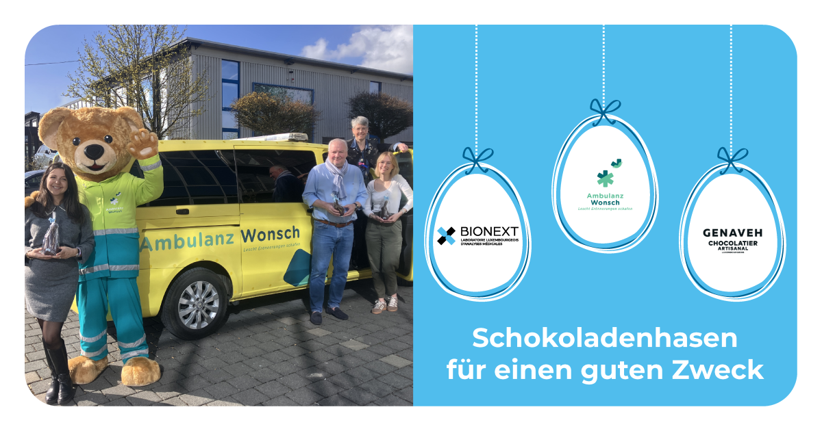 Vor einem gelben Fahrzeug von Ambulanz Wonsch posieren vier Erwachsene und ein lächelndes Bärenmaskottchen gemeinsam im Freien, jeweils mit einem Schokoladenhasen in der Hand. Rechts zeigt eine Grafik die Logos von BIONEXT, Ambulanz Wonsch und Genaveh sowie die Botschaft: ‚Schokoladenhasen für einen guten Zweck.