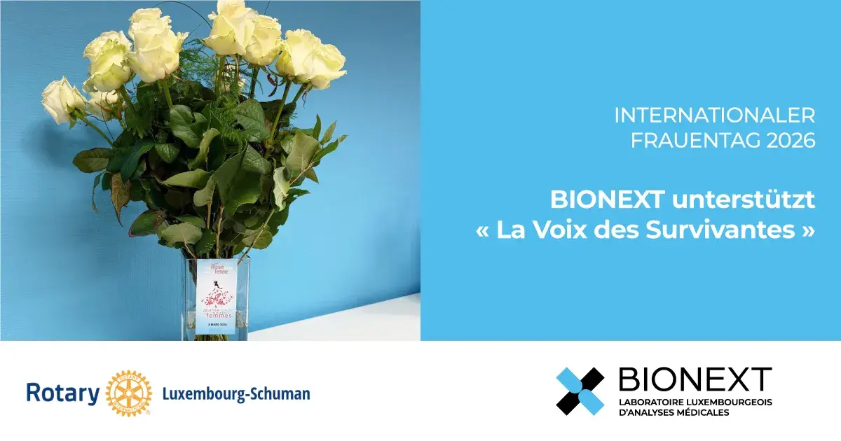 Strauß weißer Rosen in einer Vase zum Internationalen Frauentag 2026 mit dem Hinweis „BIONEXT unterstützt La Voix des Survivantes“, zusammen mit dem Rotary Club Luxembourg-Schuman.